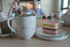 Pyszna herbata i ciasto, a w tle siedzą Panie