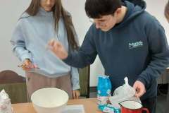 Dzieci przygotowują ciasto na pączki