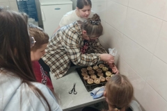 Pani prowadząca dekoruje pączki