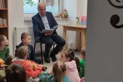Wójt czyta dzieciom książkę