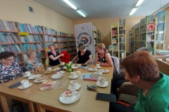 Panie siedzą przy stole i rozmawiają