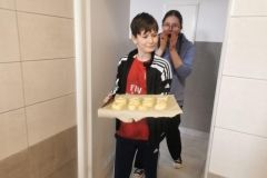 dzieci niosą ciasto do piekarnika